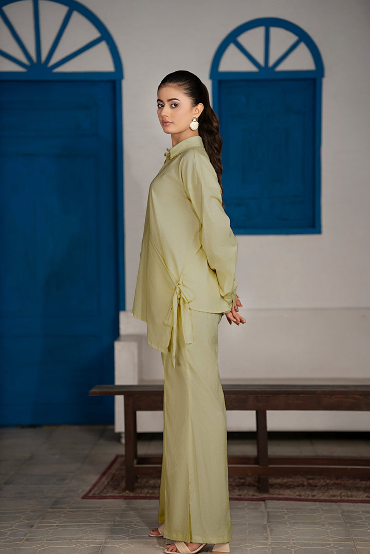 Side profile showing crossover belt design and wide flowing trousers in olive green set